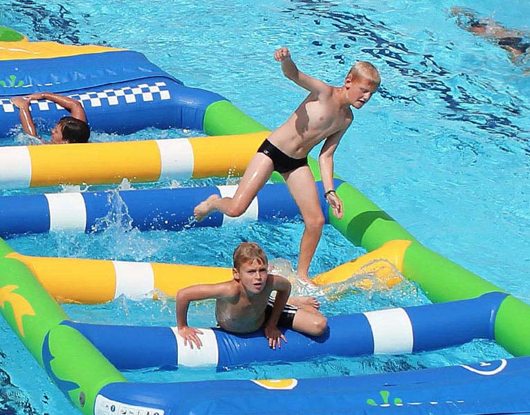 Enfants jouant sur un Aqua Track dans la piscine du camping à Arvert