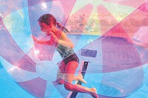 Enfant jouant dans une bulle aquatique dans la piscine du camping Parc de Bellevue